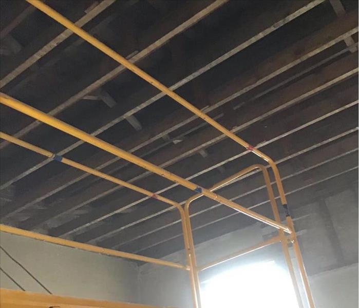 Open ceiling showing the studs with a yellow ladder.