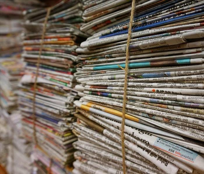 Stacks of newspapers bundled with a brown rope.