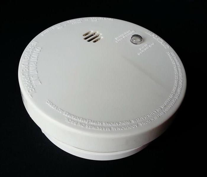 White smoke alarm with a black background.